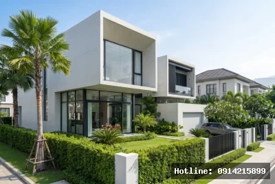 Góc nhìn chính diện mặt tiền | Ngôi nhà hiện đại với vật liệu bê tông và kính, tạo nên sự cân bằng giữa sự chắc chắn và trong suốt. Phong cách thiết kế đơn giản với các khối hình học rõ nét, hòa quyện cùng không gian xanh mát của cây cối xung quanh. Ánh sáng tự nhiên tràn ngập, mang lại cảm giác thoáng đãng và gần gũi với thiên nhiên.