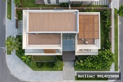 Góc nhìn từ trên xuống | Công trình kiến trúc này thể hiện phong cách hiện đại với việc sử dụng vật liệu bê tông và gỗ kết hợp hài hòa, tạo cảm giác ấm cúng và thanh lịch. Ánh sáng tự nhiên được tối ưu hóa qua việc sử dụng nhiều cửa kính lớn, giúp không gian bên trong thoáng đãng và gần gũi với thiên nhiên. Xung quanh ngôi nhà là những dãy cây xanh mướt mắt, mang lại cảm giác tươi mát và thư thái cho người sử dụng.