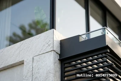 Cận cảnh chi tiết vật liệu | Mặt tiền sử dụng đá tự nhiên màu trắng với bề mặt thô ráp, tạo nên sự tương phản tinh tế với khung kim loại màu đen sắc nét của lan can. Phong cách thiết kế hiện đại, tối giản, nhấn mạnh vào các đường thẳng và hình khối rõ ràng. Ánh sáng tự nhiên tràn ngập không gian, khiến không gian trở nên rộng rãi và thoáng đãng, tạo cảm giác thanh thoát và yên bình.